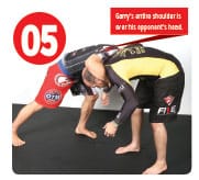 Once his head is down, Garry brings his arm up and over his opponent’s neck.