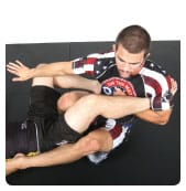 B. He then pushes the left leg away and brings his right knee up between his opponent’s legs to isolate the target leg.