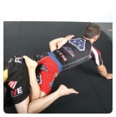 D. Garry adjusts the hold so that the top of his opponent’s right foot is up against Garry’s left triceps and he bridges into the target leg with his right hand on the mat.